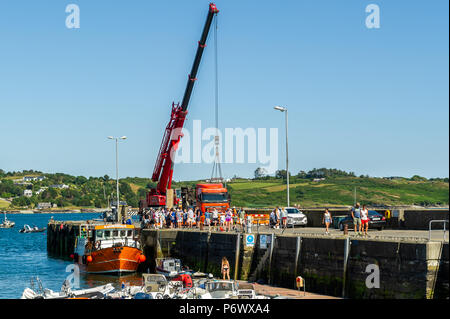 Schull, West Cork, Irlande. 3 juillet 2018. Les entrepreneurs lèvent une partie de la barge que les ouvriers utiliseront pour construire le nouveau ponton dans l'eau tandis que le ferry Cape Clear décharge ses passagers après un voyage sur l'île. Crédit : AG News/Alay Live News. Banque D'Images