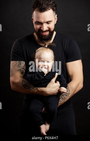 Portrait d'homme adulte masculin avec des corps en parfaite harmonie avec le bébé sur les mains . Père aimant holding et prendre soin de bébé adorable daugter. Banque D'Images