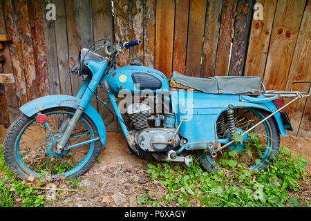 Un vieux stand moto abandonnée près d'une clôture dans le village Banque D'Images