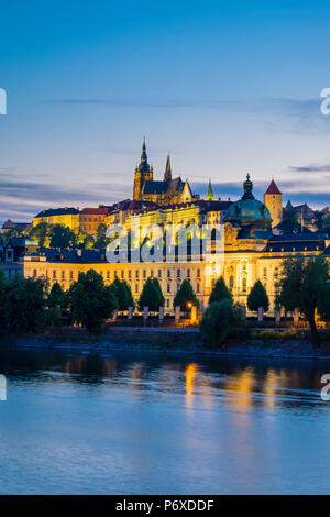 République tchèque, Prague. Le Château de Prague (Prazsky Hrad) et l'Ecole Straka (Strakova akademie) le siège du Gouvernement de la République tchèque, sur la Vltava au crépuscule. Banque D'Images