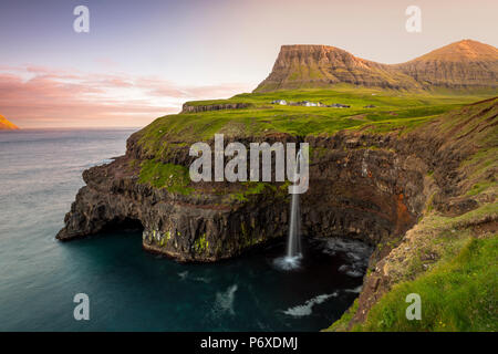 Gasadalur, Vagar et Île, Îles Féroé, Danemark. La célèbre cascade d'un saut d'la falaise dans l'océan. Banque D'Images