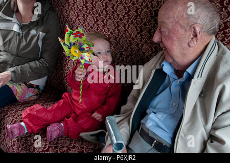 Tout-petit en montrant son grand-père de l'enfant jouet moulin colorés Banque D'Images