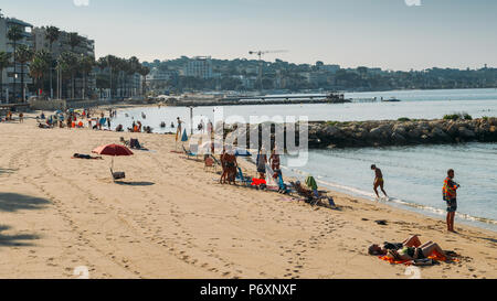 Soleil du matin les baigneurs et la baignade à la plage de Juan les Pins, une destination touristique populaire sur la Méditerranée Banque D'Images