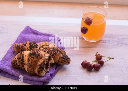 Pain au chocolat avec des cerises et des jus d'orange frais pressé à fond en bois// fond Petit-déjeuner Petit-déjeuner sucré/ partir un jour Banque D'Images