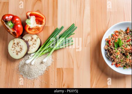 Délicieux ragoût de quinoa avec les ingrédients de référence sur un fond de bois Banque D'Images