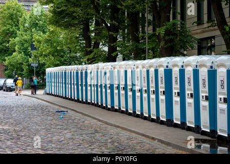 RIGA, Lettonie - 22 juin 2018 : marché du solstice d'été. Sur le bord de la rue de la ville il y a une ligne avec des toilettes publiques. Banque D'Images