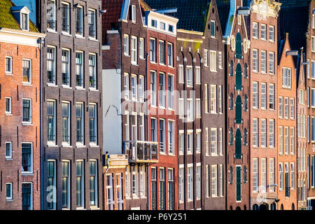 Pays-bas, Amsterdam, Hollande du Nord. Façades de maisons du canal de travers sur le Damrak. Banque D'Images