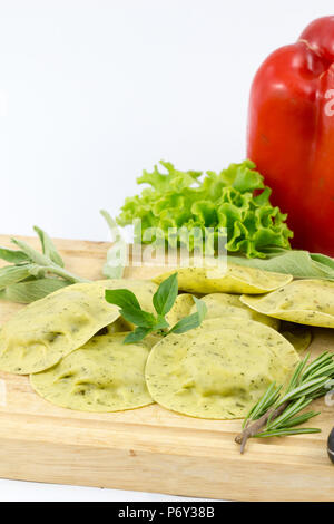 Raviolis pâtes italiennes avec herbe verte sur fond blanc bois / des pâtes raviolis et bois avec vintage mug de farine et de basilic frais / fresh p Banque D'Images