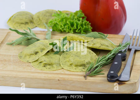 Raviolis pâtes italiennes avec herbe verte sur fond blanc bois / des pâtes raviolis et bois avec vintage mug de farine et de basilic frais / fresh p Banque D'Images