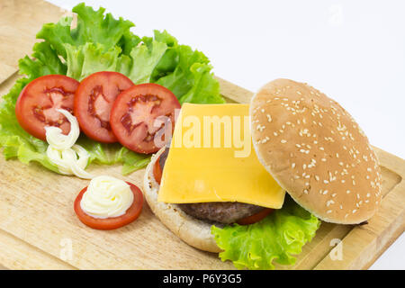 Hamburger fait maison avec salade, tomate, fromage, viande de boeuf et frites placés sur fond de bois , frais délicieux burger, d'arrière-plan Banque D'Images