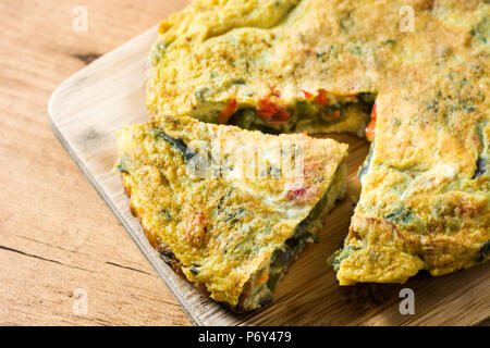 Faites de la frittata des œufs et des légumes sur la table en bois. Banque D'Images