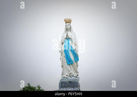 Soft focus. Des statues de Saintes Femmes sur fond de ciel nuageux / Statue de la Vierge Marie avec des tons doux. Banque D'Images