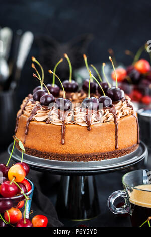 Délicieux gâteau au fromage au chocolat maison décorée avec des cerises fraîches Banque D'Images
