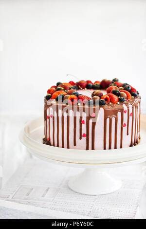 Délicieux petit gâteau décoré avec du chocolat et de baies fraîches Banque D'Images