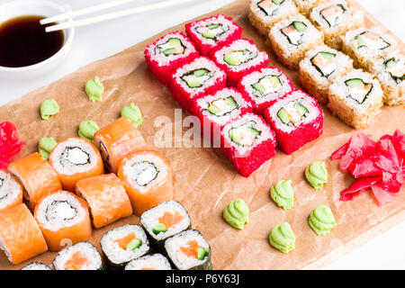 Ensemble de différents types de rouleaux de sushi japonais sur planche de bois Banque D'Images