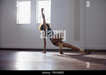 Jeune danseuse gracieuse exerçant dans un studio de danse Banque D'Images