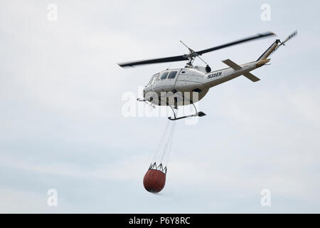 1 juillet 2018 - Un hélicoptère Bell UH-1 Iroquois a été utilisé pour verser 1 000 litres d'eau de flammes dans l'hiver Hill fire. Les équipes de pompiers de tout le Royaume-Uni ont convergé sur la colline d'hiver pour contrôler l'incendie qui est de plus en mètres par heure. D'Incendie et de secours et du Lancashire Police Lancashire montrent la réponse à l'incident "majeure". Banque D'Images