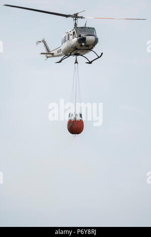 1 juillet 2018 - Un hélicoptère Bell UH-1 Iroquois a été utilisé pour verser 1 000 litres d'eau de flammes dans l'hiver Hill fire. Les équipes de pompiers de tout le Royaume-Uni ont convergé sur la colline d'hiver pour contrôler l'incendie qui est de plus en mètres par heure. D'Incendie et de secours et du Lancashire Police Lancashire montrent la réponse à l'incident "majeure". Banque D'Images