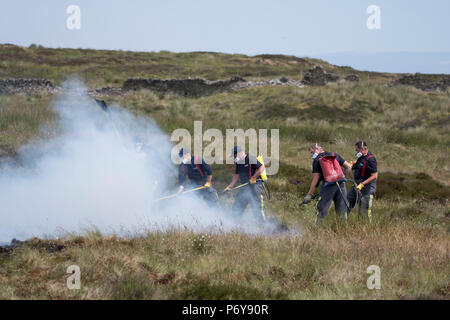 1 juillet 2018 - Un groupe de travail des pompiers pour combattre le feu Winter Hill ensemble. Les équipes de pompiers de tout le Royaume-Uni ont convergé sur la colline d'hiver pour contrôler l'incendie qui est de plus en mètres par heure. D'Incendie et de secours et du Lancashire Police Lancashire montrent la réponse à l'incident "majeure". Banque D'Images