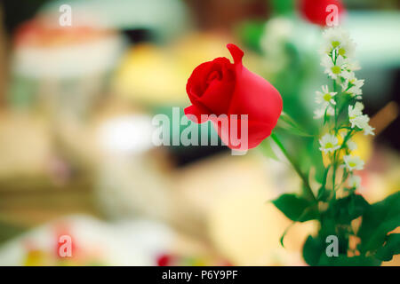 Selective focus Rose Rouge Fleur décoration sur table dîner romantique en occasion spéciale concept avec arrière-plan flou et copiez l'espace. Banque D'Images