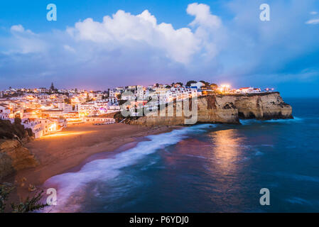 Carvoeiro, Lagoa, Algarve, Portugal. Les lumières de la ville au crépuscule. Banque D'Images