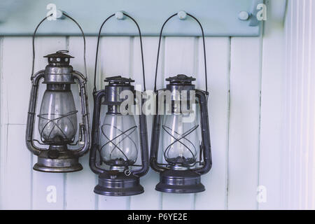 Trois lampes à huile traditionnel en bois sur la pendaison porte manteau bleu clair Banque D'Images