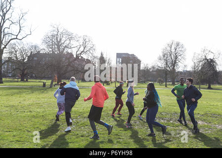 Glissières de jogging en cercle dans le parc ensoleillé Banque D'Images