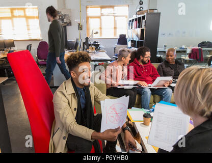 Creative business people discussing paperwork, dans open plan office Banque D'Images