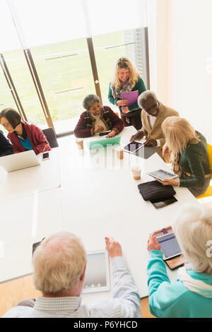 Les gens d'affaires à l'aide de tablettes numériques et ordinateurs portables dans la salle de conférence réunion Banque D'Images