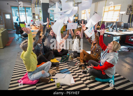 Espiègle, enthousiaste de l'équipe entreprises créatives dans les frais généraux de la paperasserie lancer open plan office Banque D'Images