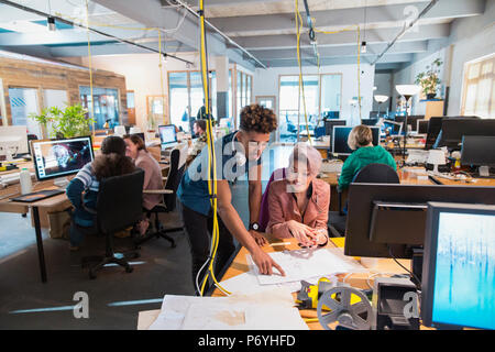 Creative business people discussing paperwork, dans open plan office Banque D'Images