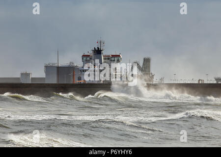 Mur nord du Port de Leixoes, nord du Portugal, dans le vent et la mer démontée après-midi voir un voile le déchargement de produits chimiques Banque D'Images