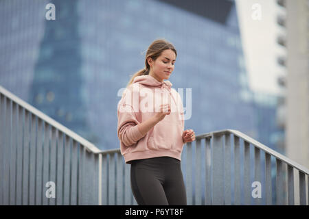 Mettre en place jolie fille courir vers le haut des escaliers avec arrière-plan de la ville Banque D'Images