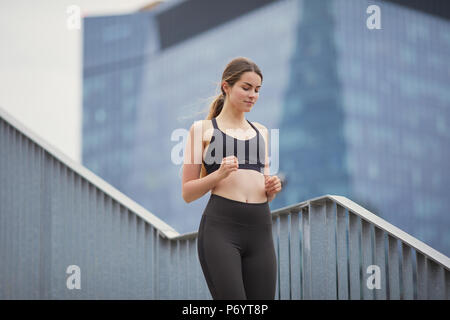 Mettre en place jolie fille courir vers le haut des escaliers avec arrière-plan de la ville Banque D'Images