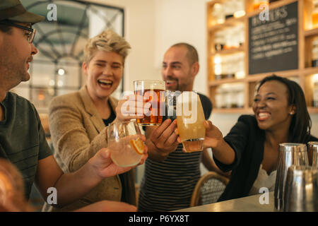 Amis ensemble dans un bar avec des boissons d'encouragement Banque D'Images