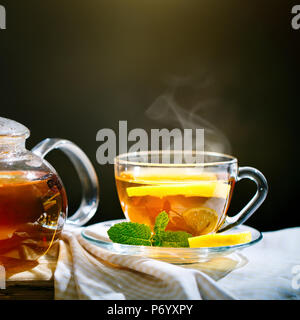 Tasse de thé noir fraîchement moulu,lumière douce chaude, fond plus sombre. Banque D'Images