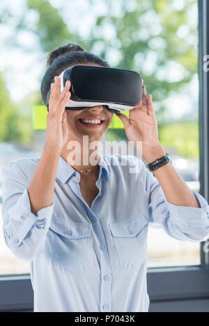 Portrait of businesswoman wearing casque de réalité virtuelle in office Banque D'Images
