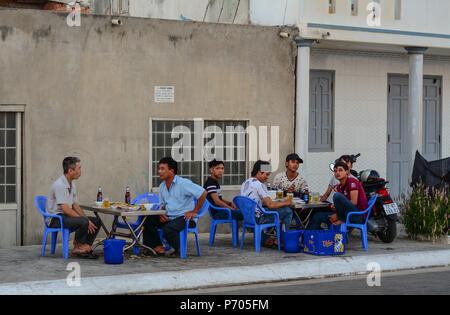 Phan Thiet, Vietnam - Mar 25, 2016. Les hommes de boire de la bière sur la rue au coucher du soleil à Phan Thiet, Vietnam. Banque D'Images