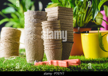 Closeup shot de piles de pots de fleurs et sur l'herbe d'un sécateur Banque D'Images