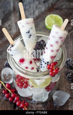 Sucettes glacées au yogourt congelé avec de petits fruits d'été Banque D'Images