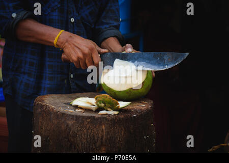 Coupes homme jeune noix de coco verte avec un chopper Banque D'Images