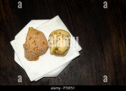 Gros plan sur deux bouche-arrosage pain fromage brésilien (Pao de Queijo") sur les serviettes blanches, sur table en bois grunge et beaucoup de copy space Banque D'Images