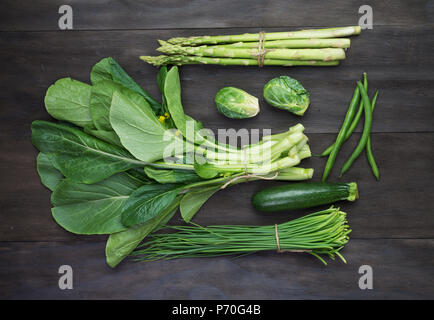 Les légumes biologiques frais vert sur noir vintage en bois.Vue de dessus de table Banque D'Images