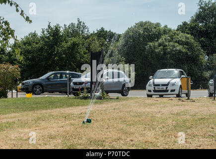 Un arrosage sprinkleur sec l'herbe brune morte arides dans le Shropshire en Angleterre, juillet 2018 Banque D'Images