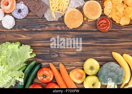 Vue de dessus de fruits frais avec des légumes et un assortiment d'aliments malsains sur table en bois Banque D'Images