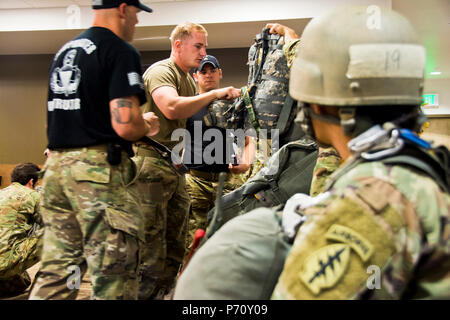 Le Sgt. Daniel Durkee, un mécanicien affecté à la 10e Groupe des forces spéciales (Airborne), effectue une inspection du personnel de parachutisme (JMPI) comme sa femme, Sgt. Angel Durkee, montres pendant un cours de saut de ligne à l'électricité statique qui s'est tenue en mai à Fort Carson, Colorado étudiants dans le cours sont censés être en mesure d'JMPI trois cavaliers en moins de cinq minutes tout en identifiant correctement les lacunes avec leur équipement. Le Durkees, qui se sont rencontrés à l'école secondaire, sont maintenant mariés et servir ensemble dans 10e Groupe. Banque D'Images