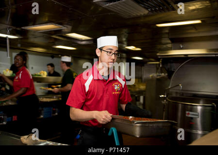 PORTSMOUTH (Virginie (11 mai 2017) Spécialiste culinaire David Seaman transferts Kinard un plateau de boulettes à bord du navire d'assaut amphibie USS Wasp LHD (1) pour le premier repas à bord du navire depuis le début de sa période de cour. Le Wasp est actuellement l'objet d'une période de constitution de la disponibilité progressive prévue à BAE Systems Naval Shipyard tandis que les préparatifs de son prochain port d'attache passage à Sasebo, au Japon. Banque D'Images