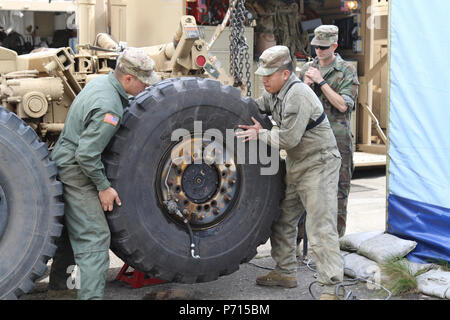 La FPC. Corey Smith, gauche, de Littleton, Colorado, et Pvt. Daniel Hernandez, de San Jose, en Californie, les deux M1A2 Abrams char de combat principal de la maintenance du système avec 64e Bataillon de soutien de la Brigade Blindée, 3e Brigade Combat Team, 4e Division d'infanterie, enlever un pneu d'un système de charge palettisée tout en menant l'entretien à l'Dragonkasernen, Danemark, le 11 mai 2107. Les soldats se préparent pour appuyer une équipe de la brigade du réservoir du 1er Bataillon du 66e Régiment, armure, au défi de la concurrence du réservoir nordique du 15 au 18 mai. Banque D'Images