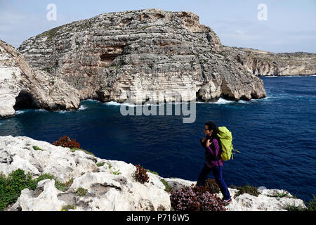 Une femme randonnées au-dessus de falaises près de la Grotte Bleue, au sud de Malte, de la Méditerranée, l'Europe Banque D'Images