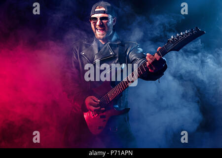 Heavy metal musicien barbu joue de la guitare électrique. Tourné dans un studio. Banque D'Images